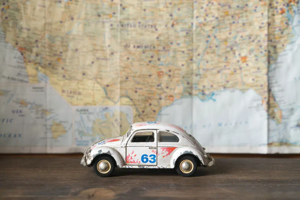 A Map with a cool little VW Bug in front of it.